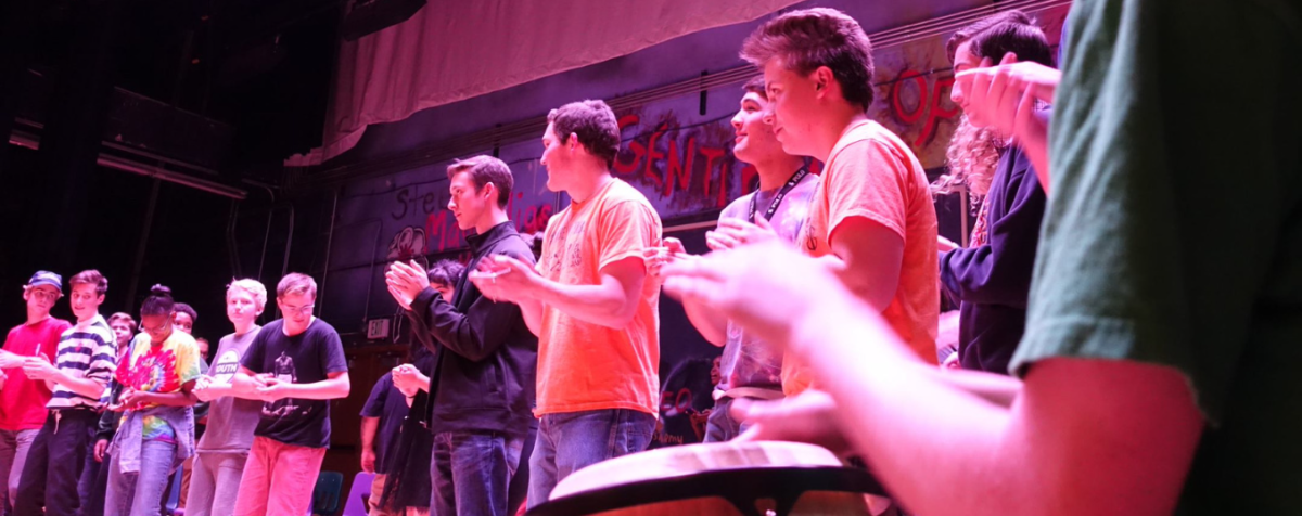 group of young people on stage with conga drummer in foreground